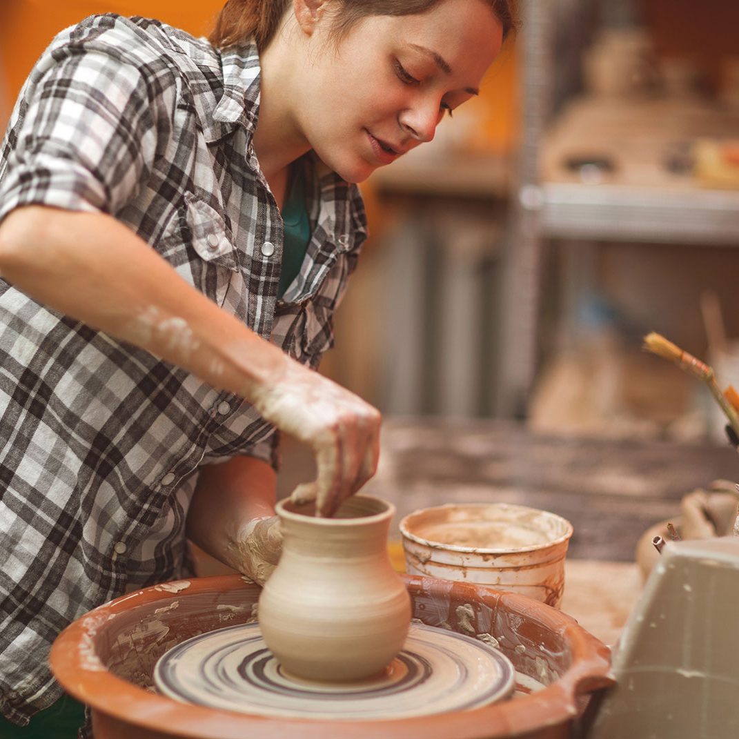 shutterstock_360472328 woman creating a clay sculpture
