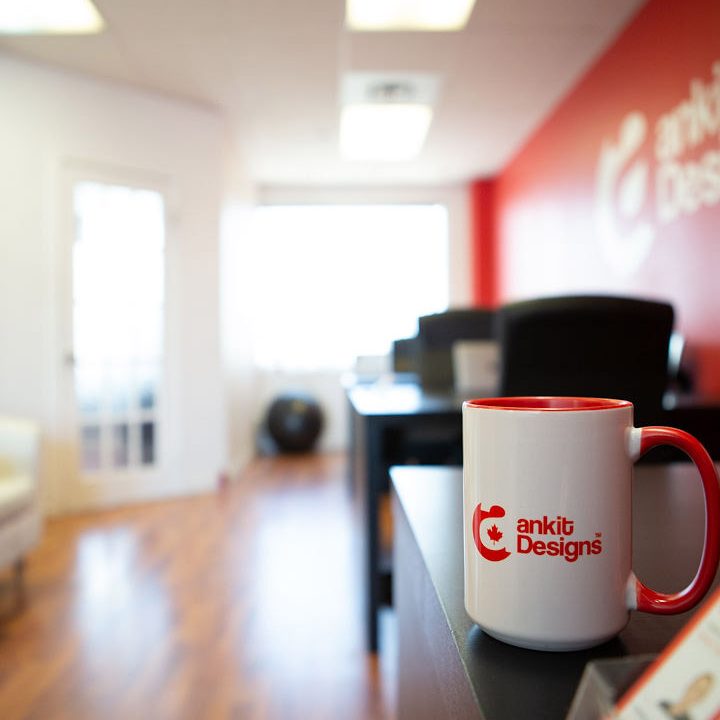 careers-circle-1 Ankit Designs branded mug sitting on a table inside Ankit Designs office lobby area